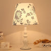 Moderne, schlichte Tischlampe mit Blumenmuster und Eisenvase